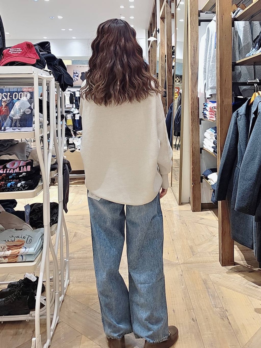 ベージュ系のダウンジャケット/コート、ブルー系のデニムパンツ、ベージュ系のショルダーバッグを着用したレディースの秋コーディネートの4枚目の写真