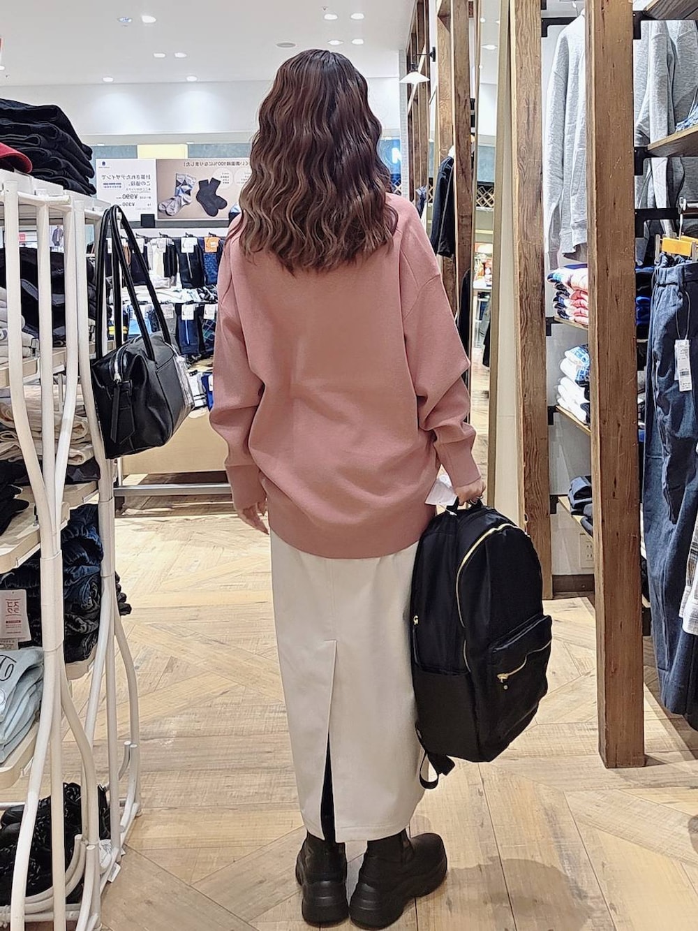 グレー系のブルゾン、ピンク系のスウェット、グレー系のスカートを着用したレディースの秋コーディネートの4枚目の写真