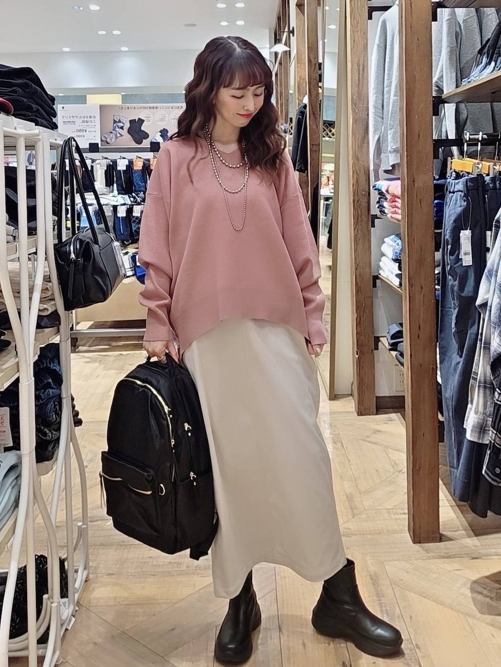 グレー系のブルゾン、ピンク系のスウェット、グレー系のスカートを着用したレディースの秋コーディネートの3枚目の写真