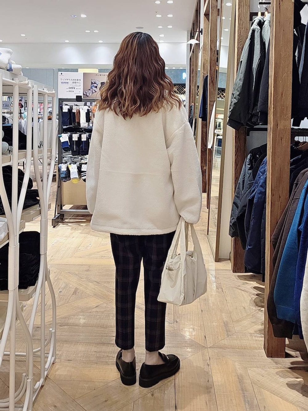 ホワイト系のブルゾン、ブルー系のその他パンツ、ブラック系のローファーを着用したレディースの秋コーディネートの2枚目の写真