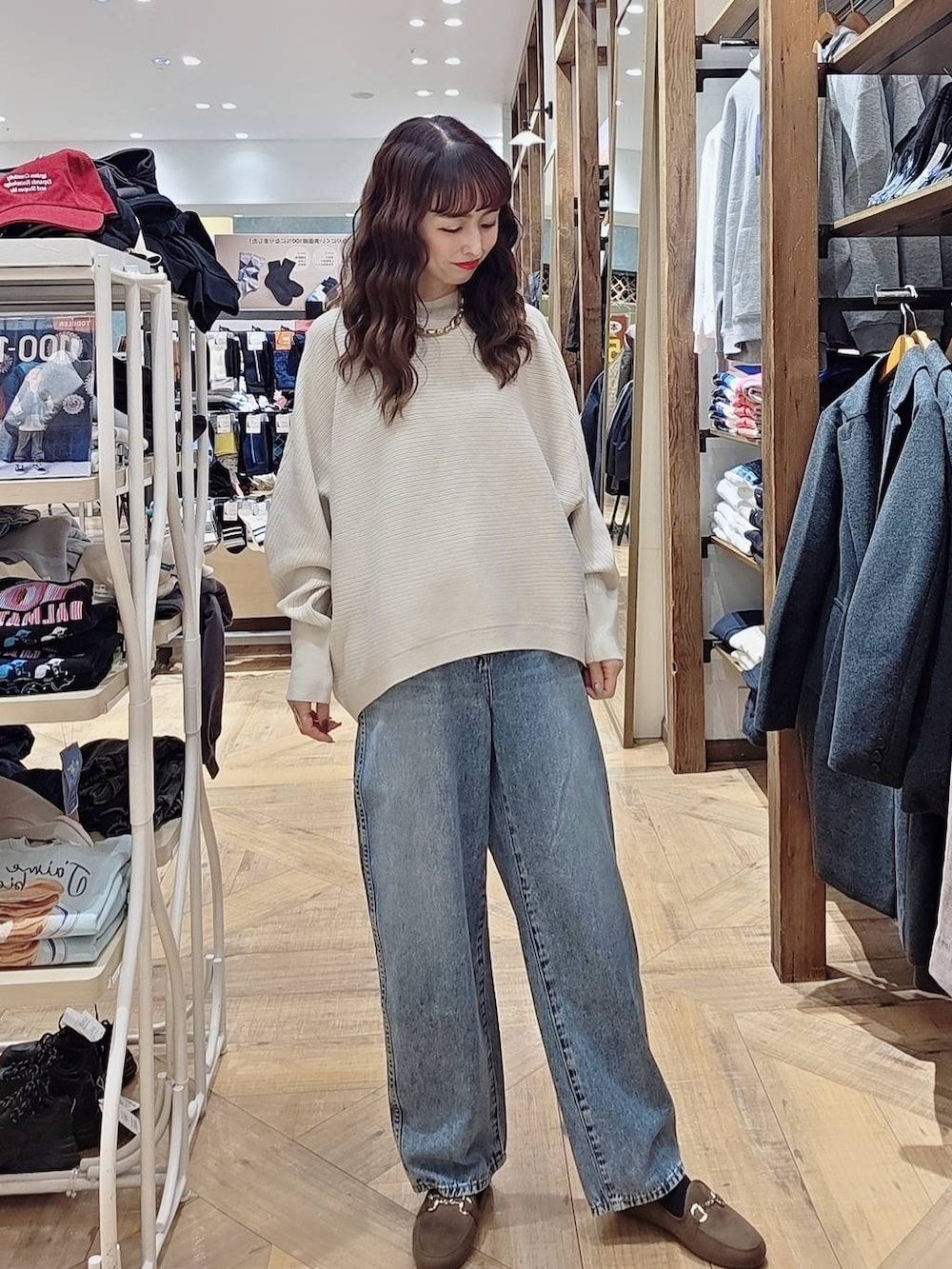 ベージュ系のダウンジャケット/コート、ブルー系のデニムパンツ、ベージュ系のショルダーバッグを着用したレディースの秋コーディネートの3枚目の写真