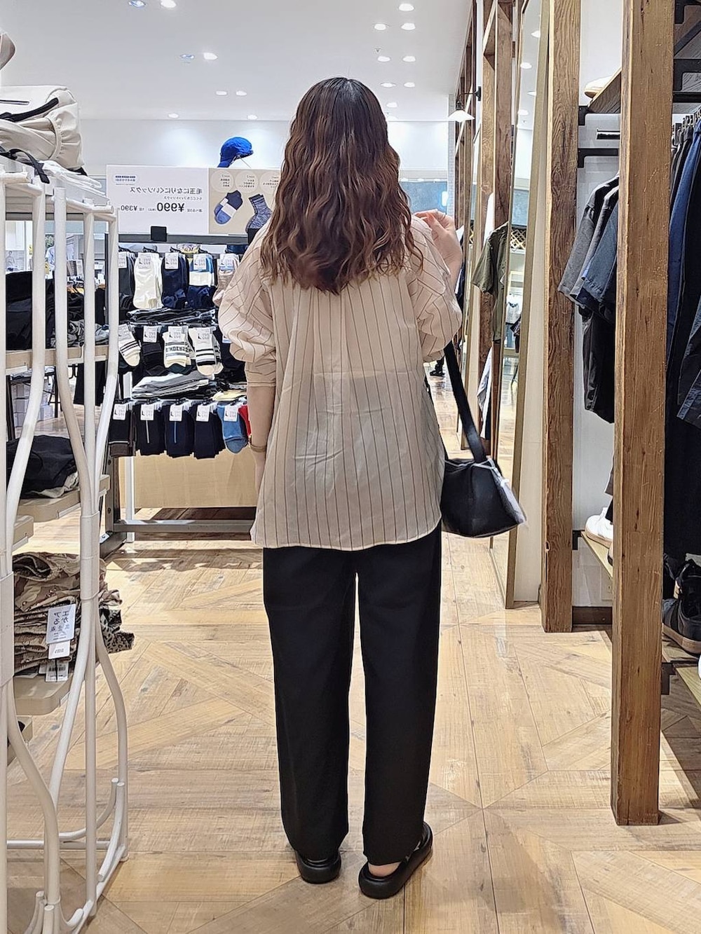 ブラック系のその他パンツ、ブラック系のショルダーバッグ、ベージュ系のシャツ/ブラウスを着用したレディースの春コーディネートの2枚目の写真