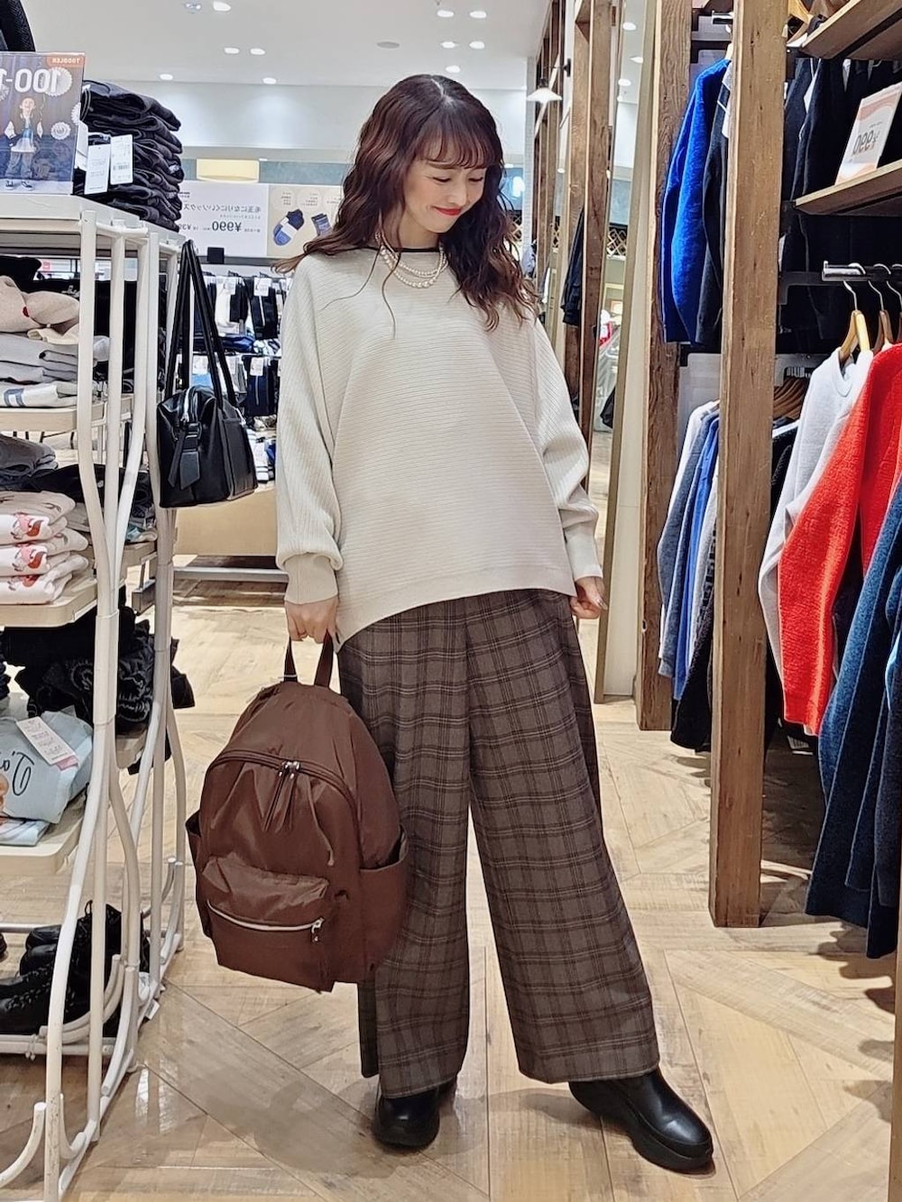 グレー系のチェスターコート、ブラック系のブーツ、ブラウン系のその他パンツを着用したレディースの冬コーディネートの3枚目の写真