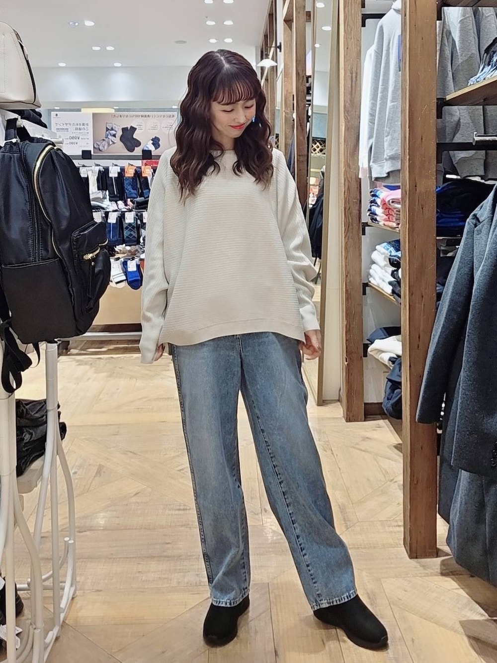 ブルー系のデニムパンツ、ブラウン系のブルゾン、ブラック系のバックパック/リュックを着用したレディースの秋コーディネートの3枚目の写真