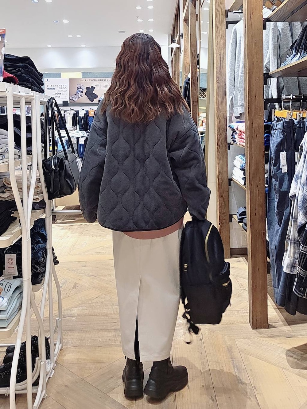 グレー系のブルゾン、ピンク系のスウェット、グレー系のスカートを着用したレディースの秋コーディネートの2枚目の写真