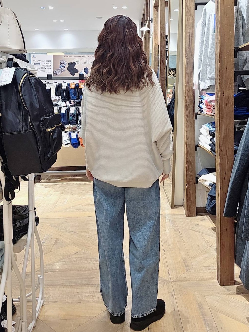 ブルー系のデニムパンツ、ブラウン系のブルゾン、ブラック系のバックパック/リュックを着用したレディースの秋コーディネートの4枚目の写真