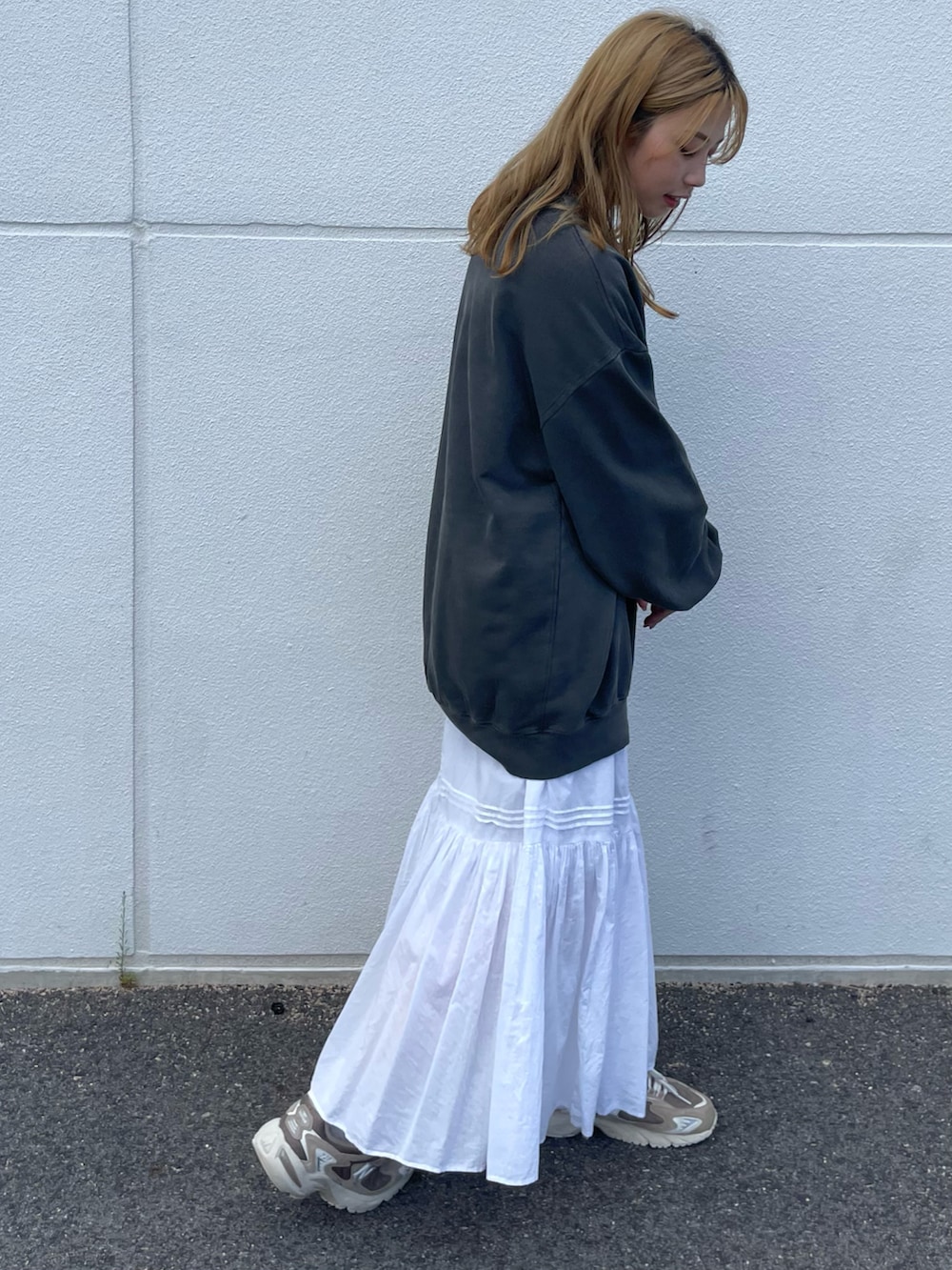 グレー系のスウェット、ブラック系のスニーカーを着用したレディースの秋コーディネートの2枚目の写真