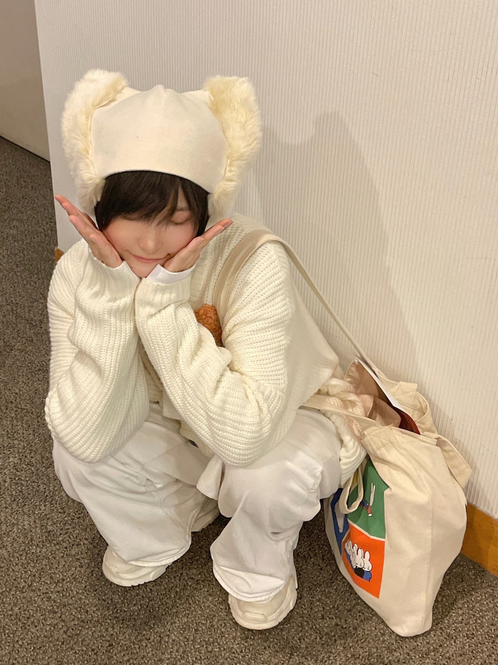 ホワイト系のデニムパンツ、ホワイト系のスニーカー、ホワイト系のカーディガン/ボレロを着用したレディースの秋コーディネートの2枚目の写真