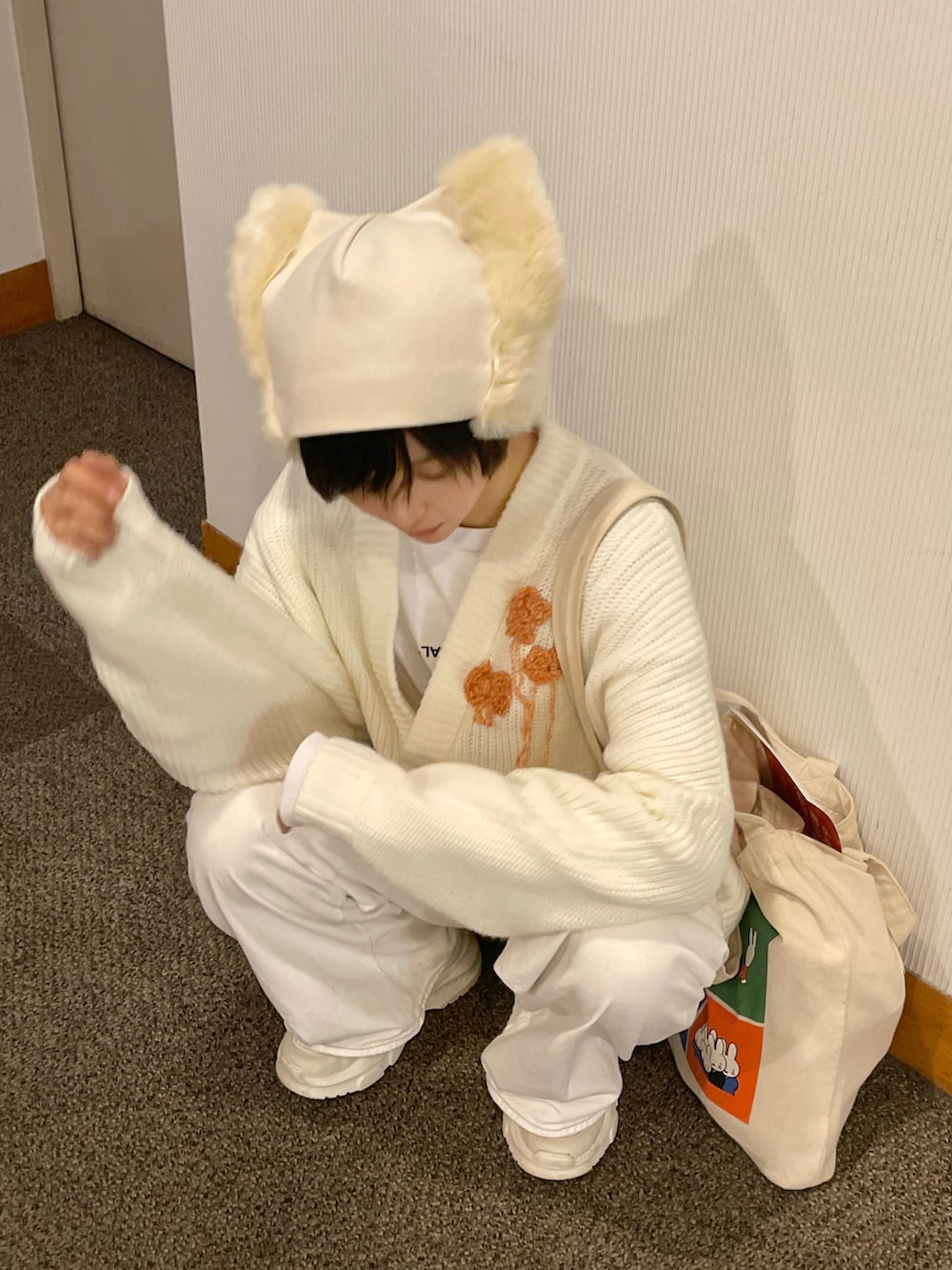 ホワイト系のデニムパンツ、ホワイト系のスニーカー、ホワイト系のカーディガン/ボレロを着用したレディースの秋コーディネートの3枚目の写真