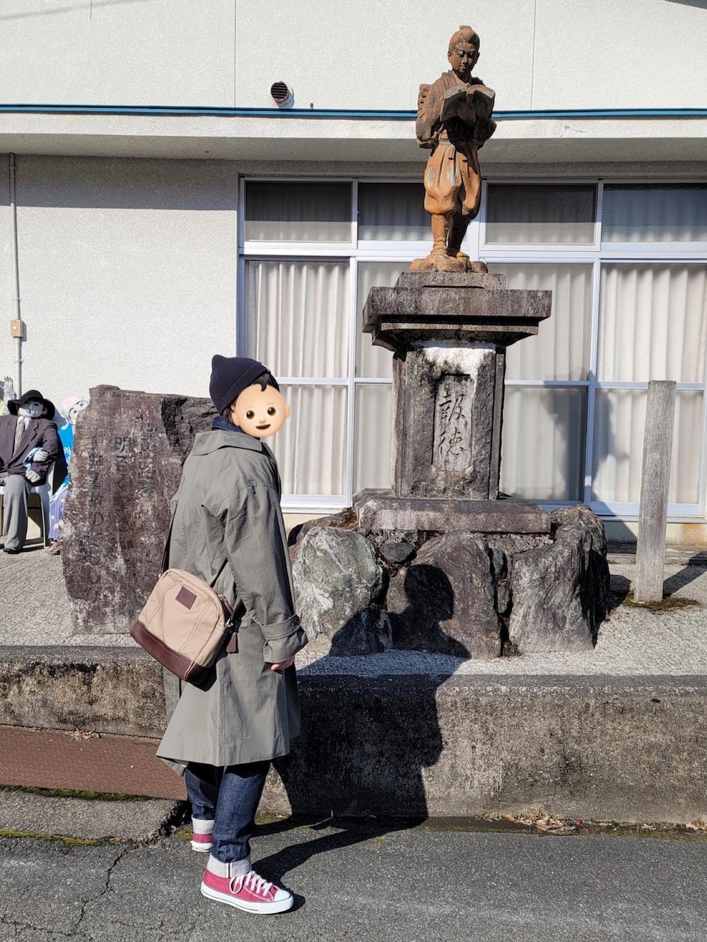 グレー系のトレンチコート、ブルー系のデニムジャケット、ブルー系のデニムパンツを着用したレディースの冬コーディネートの3枚目の写真