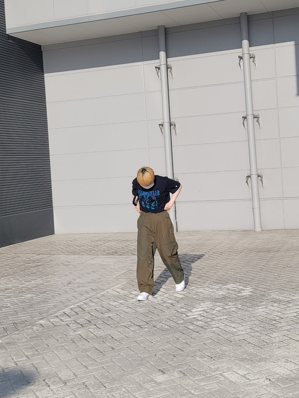 グリーン系のカーゴパンツ、ブルー系のTシャツ/カットソー、ホワイト系のスニーカーを着用したレディースの夏コーディネートの2枚目の写真