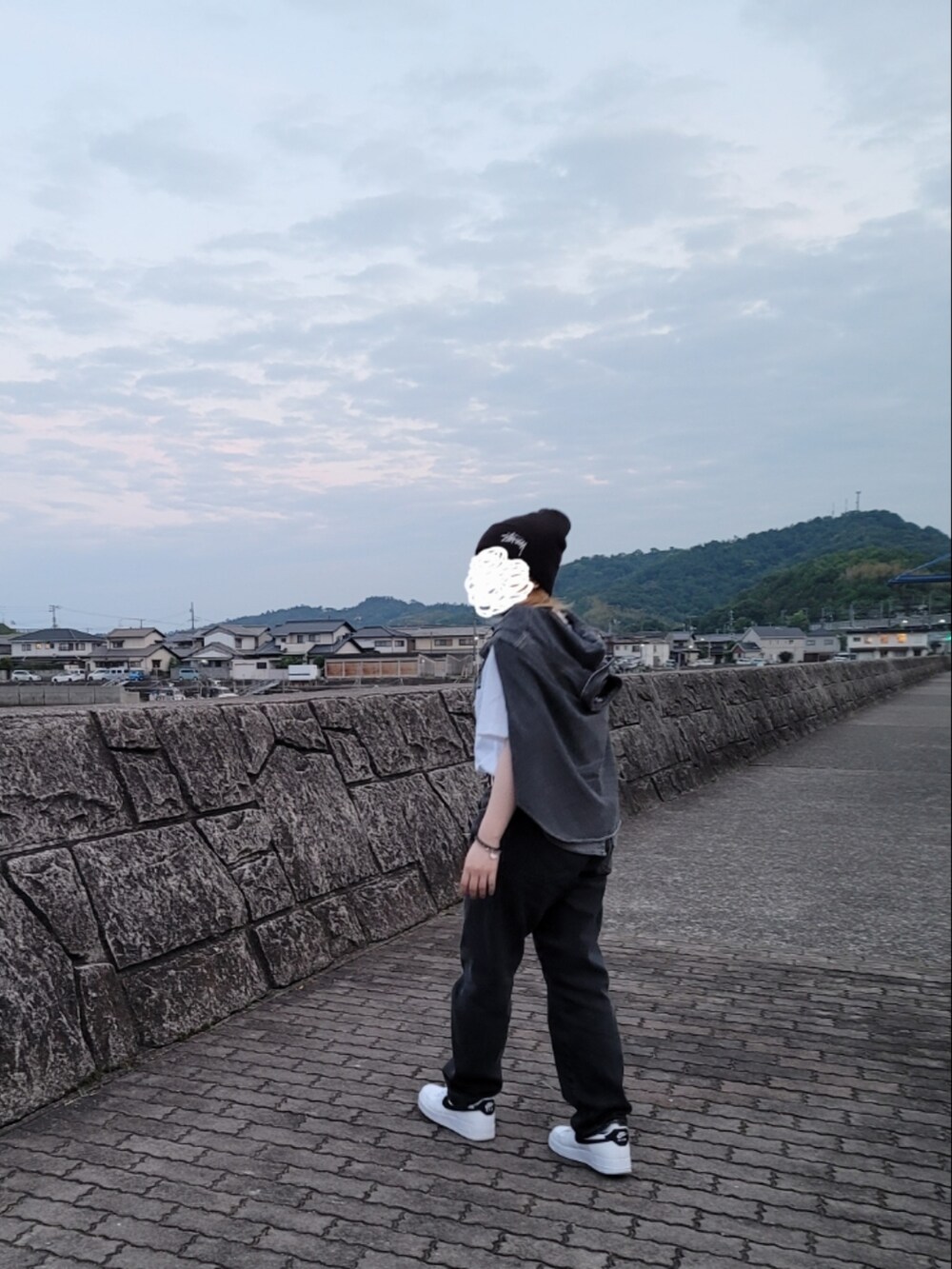 グレー系のデニムパンツ、ホワイト系のTシャツ/カットソー、ホワイト系のスニーカーを着用したレディースの春コーディネートの2枚目の写真