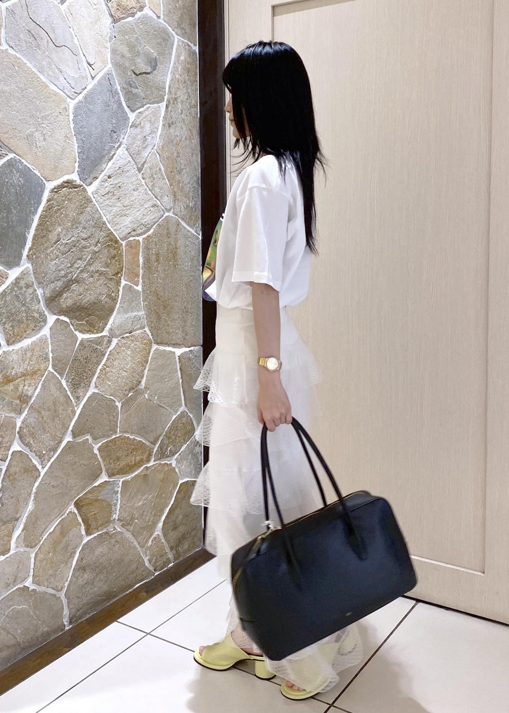 グリーン系のサンダル、ホワイト系のスカート、ブラック系のボストンバッグを着用したレディースの夏コーディネートの6枚目の写真