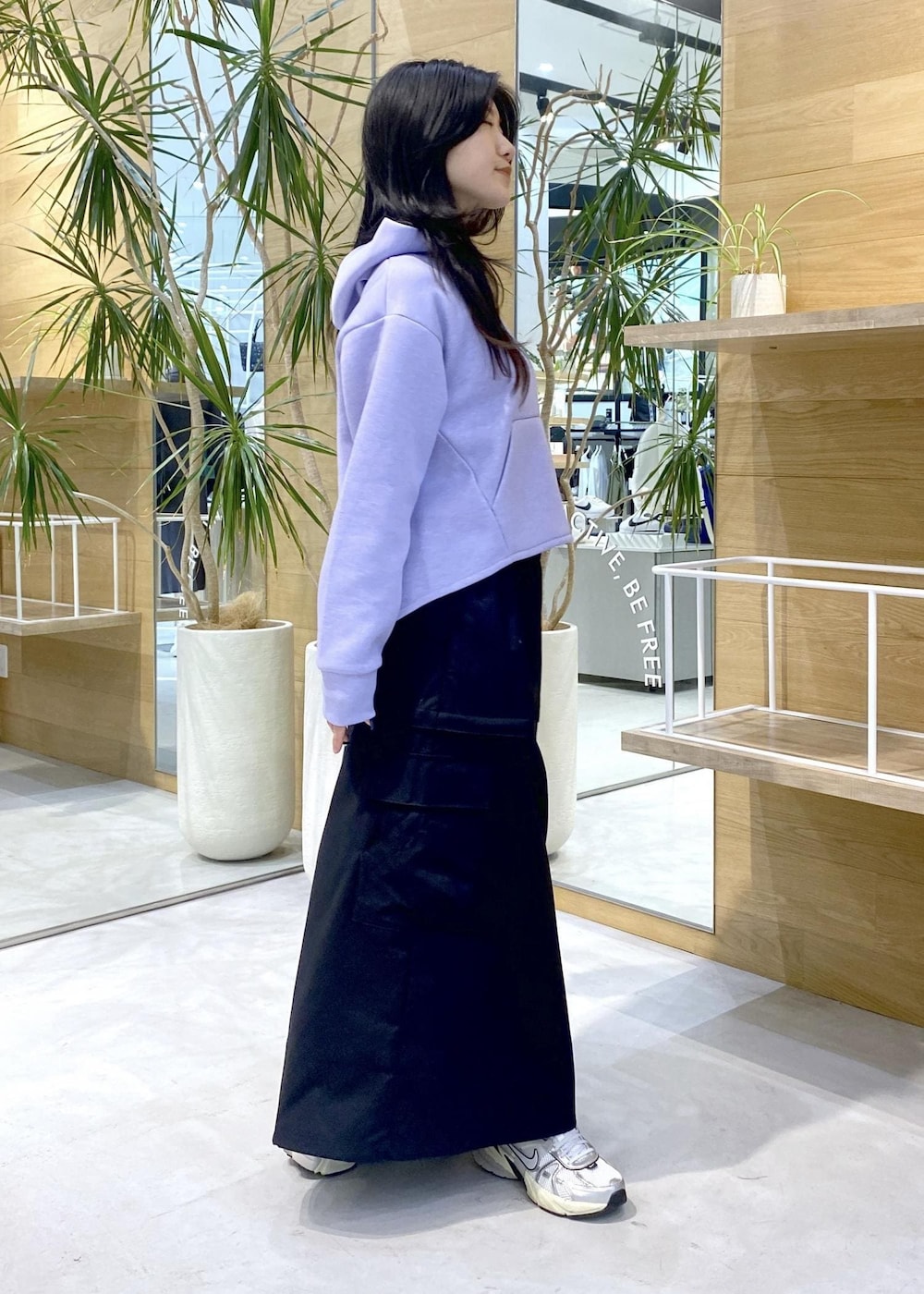 ホワイト系のスニーカー、パープル系のパーカー、ブラック系のスカートを着用したレディースの秋コーディネートの5枚目の写真