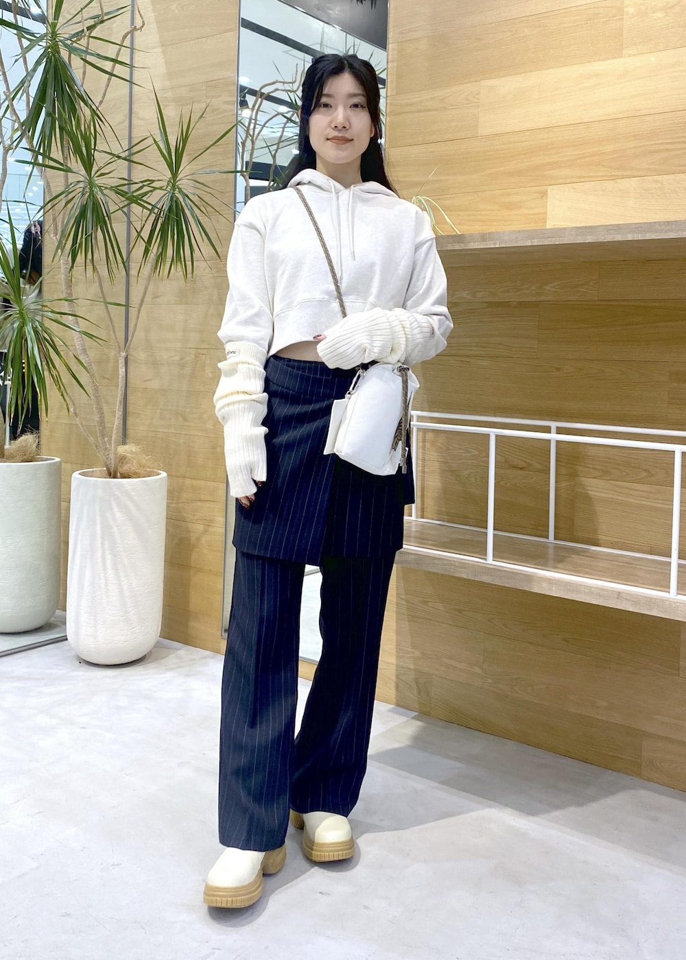 ホワイト系のショルダーバッグ、ホワイト系のブーツ、ホワイト系のパーカーを着用したレディースの冬コーディネートの2枚目の写真