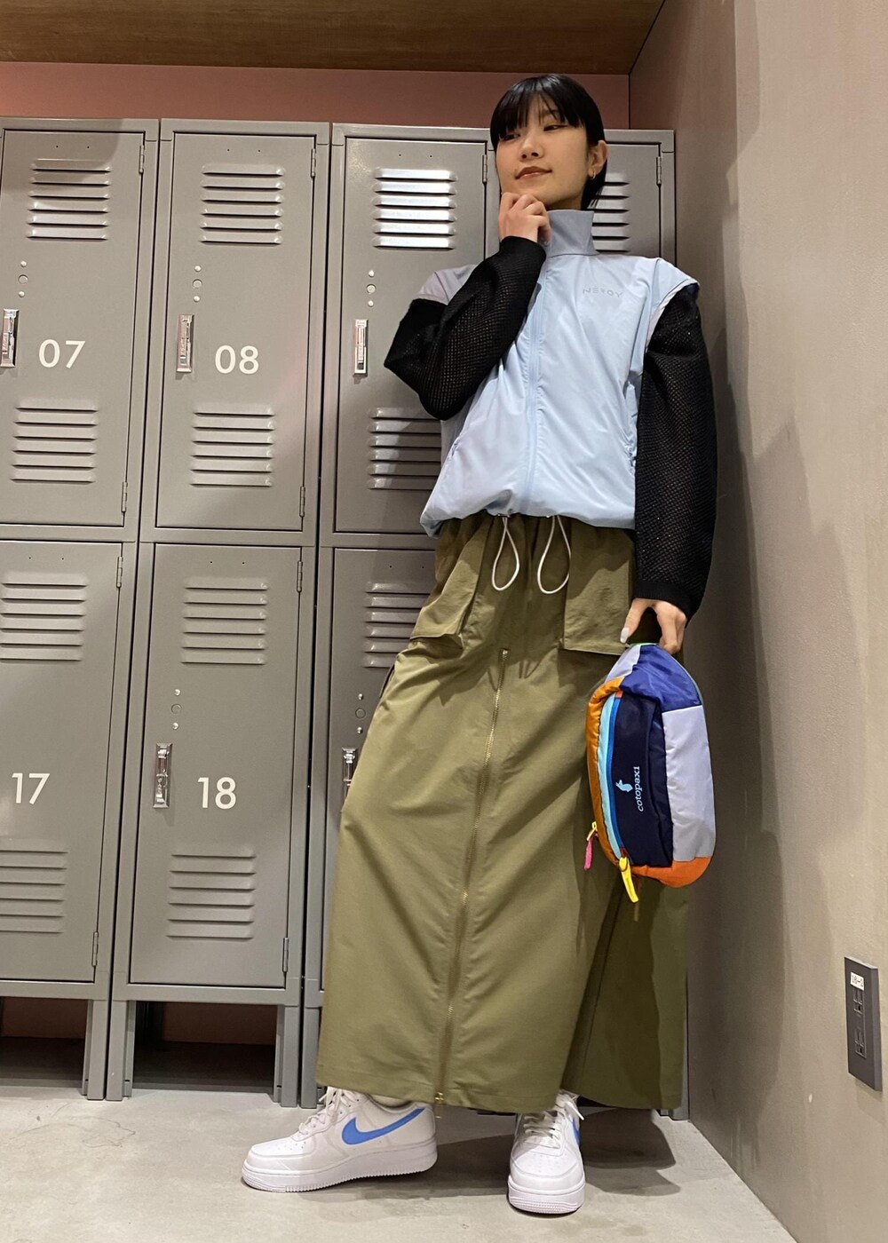 グリーン系のスカート、ブルー系のブルゾン、ブラック系のTシャツ/カットソーを着用したレディースの春コーディネートの4枚目の写真