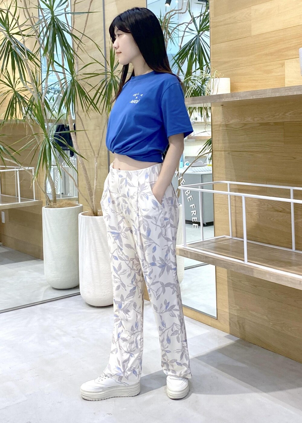 ベージュ系のその他パンツ、ホワイト系のスニーカー、ブルー系のTシャツ/カットソーを着用したレディースの夏コーディネートの3枚目の写真