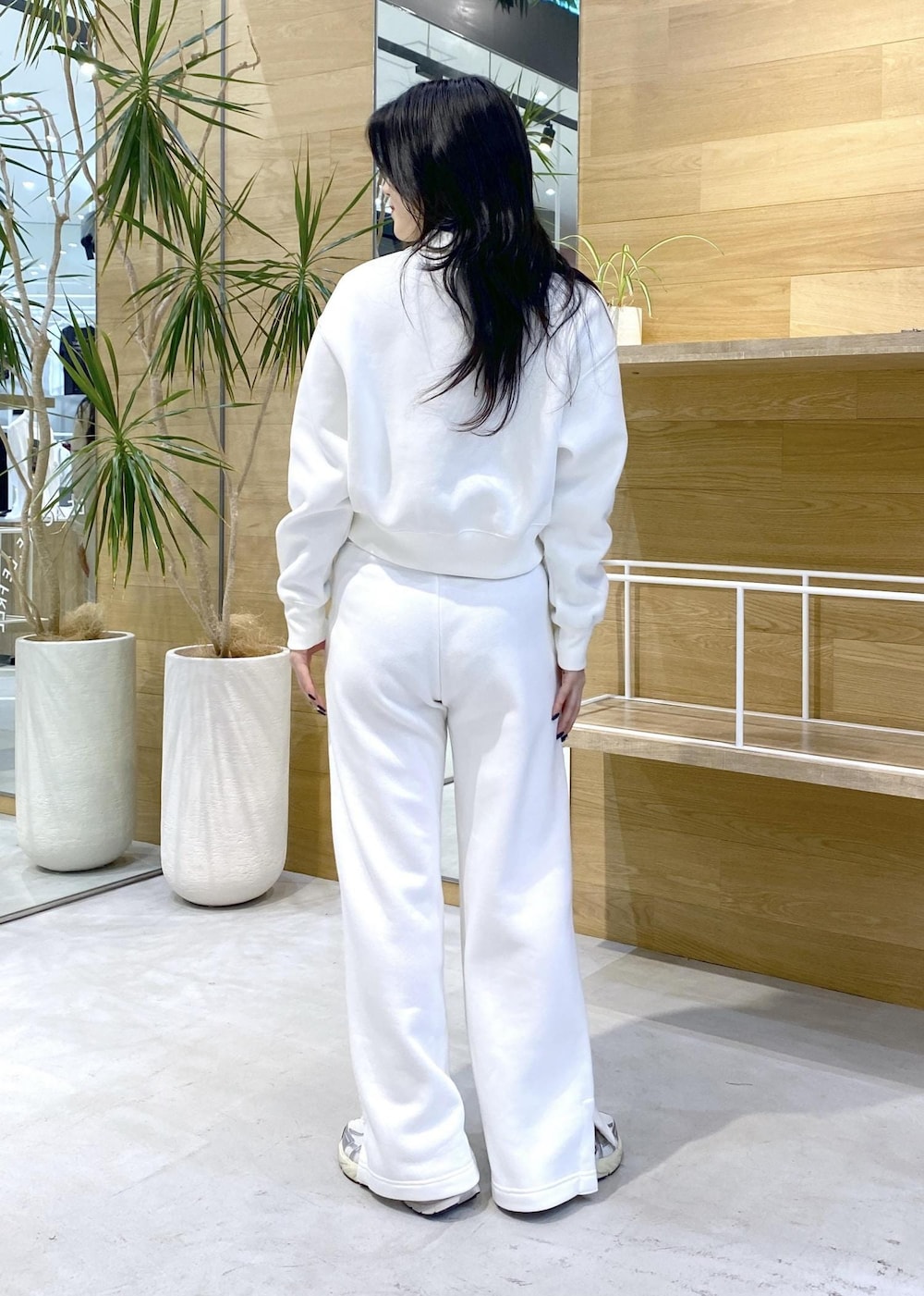 ホワイト系のスニーカー、ブルー系のニット/セーター、ブラック系のその他パンツを着用したレディースの秋コーディネートの4枚目の写真