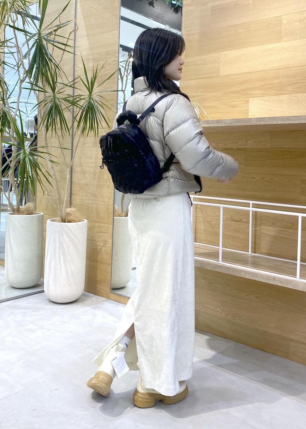 ベージュ系のダウンジャケット/コート、ホワイト系のブーツ、ホワイト系のスカートを着用したレディースの冬コーディネートの4枚目の写真