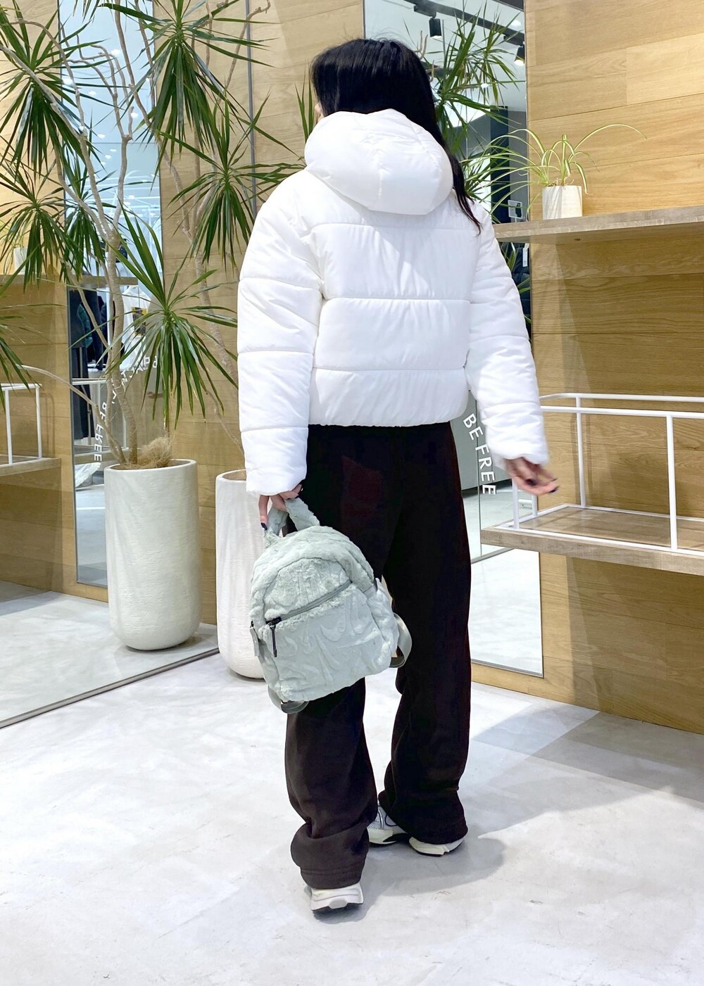 ブラウン系のその他パンツ、ホワイト系のスニーカー、ホワイト系のダウンジャケット/コートを着用したレディースの秋コーディネートの4枚目の写真