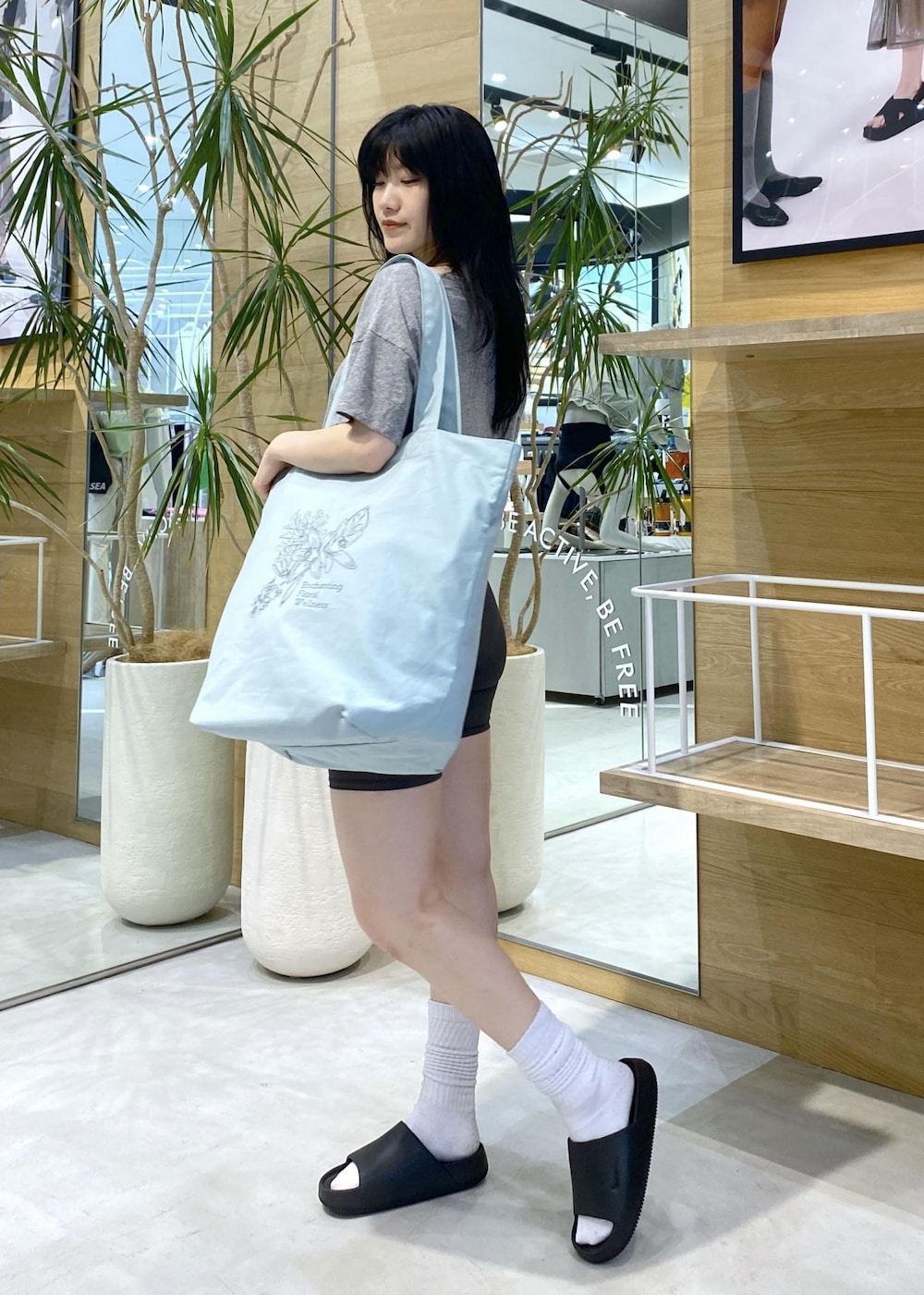 ブラック系のサンダル、グレー系のTシャツ/カットソー、グリーン系のトートバッグを着用したレディースの夏コーディネートの3枚目の写真