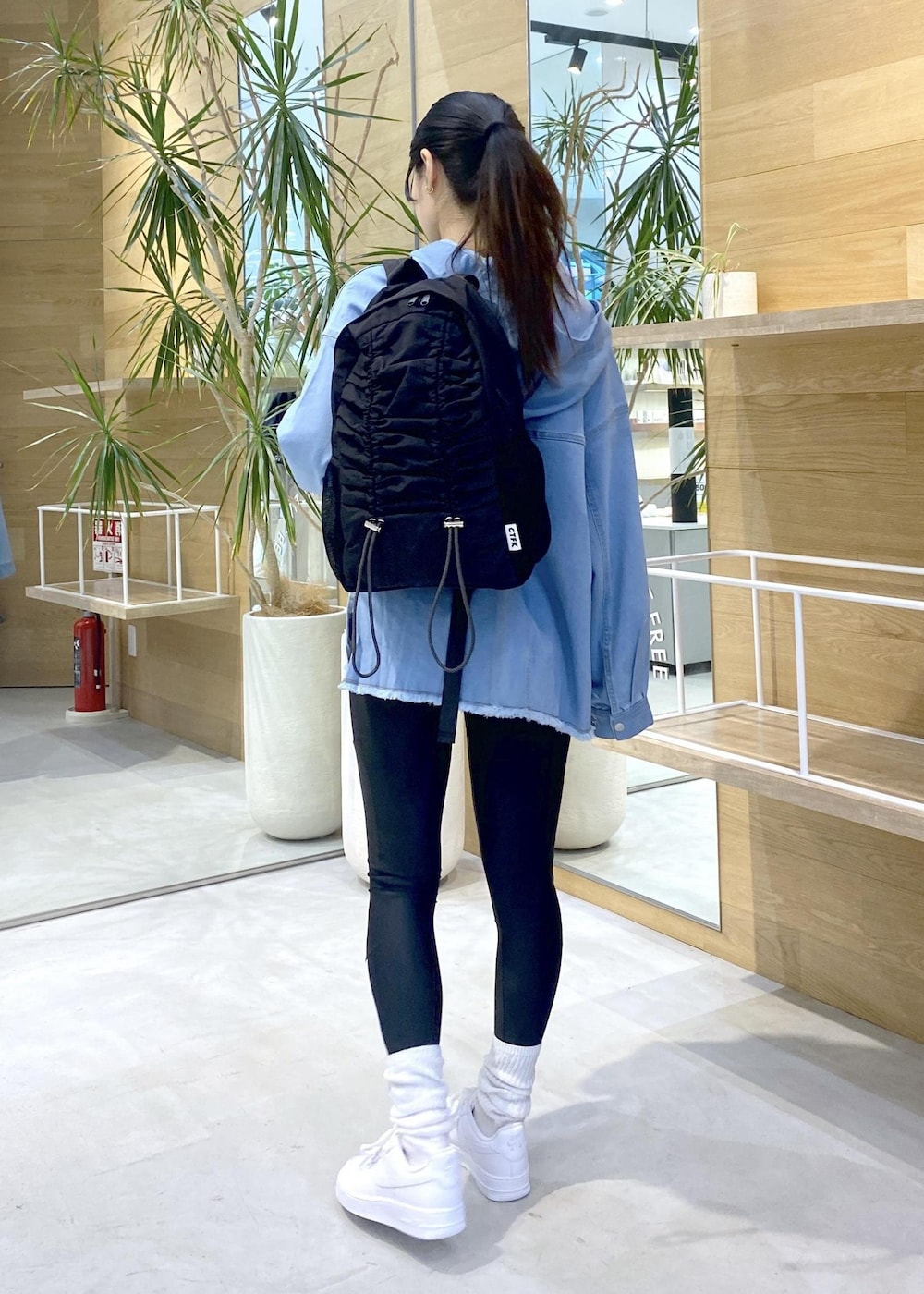 ホワイト系のスニーカー、ブルー系のパーカー、ブラック系のバックパック/リュックを着用したレディースの秋コーディネートの4枚目の写真