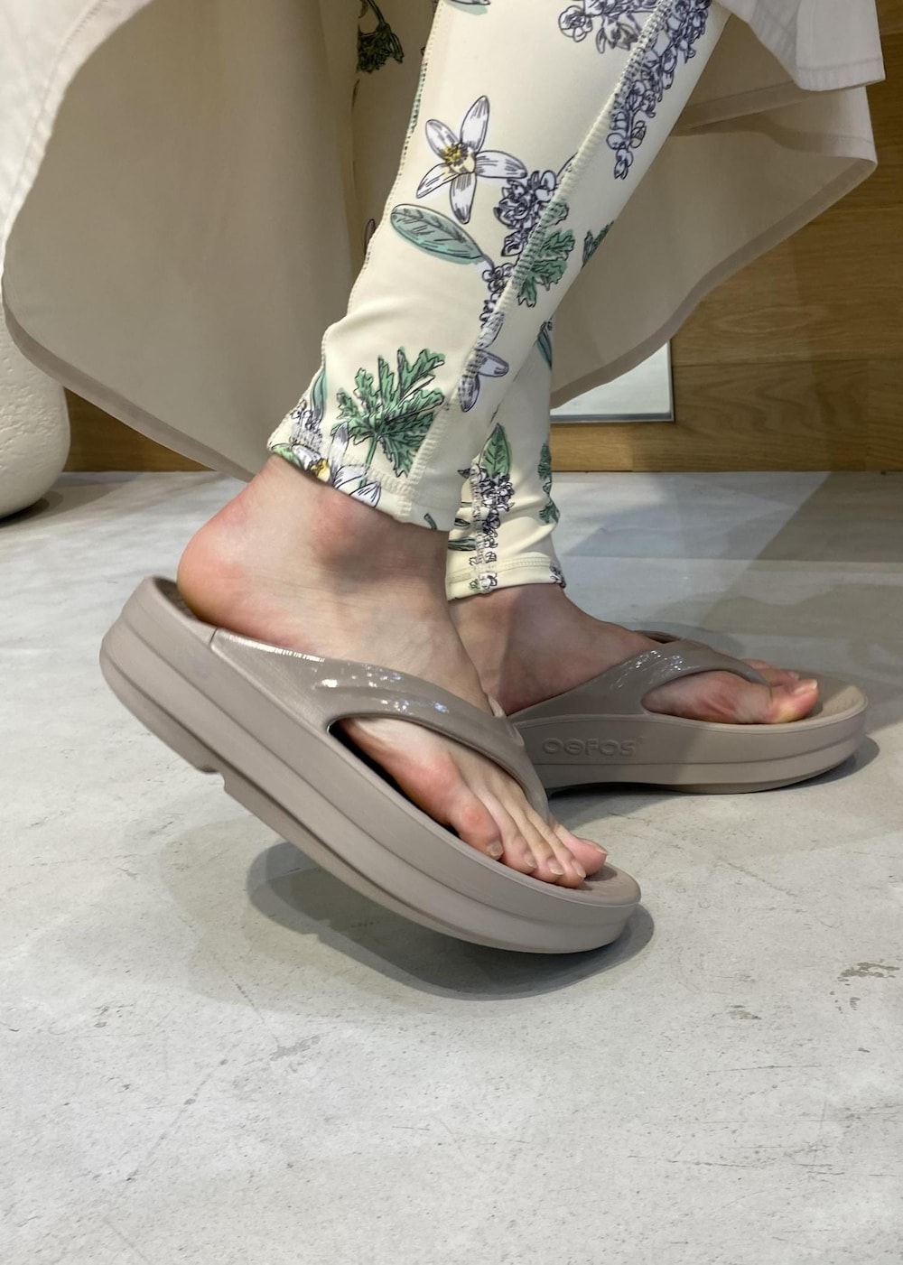 ベージュ系のサンダル、ホワイト系のラッシュガード、グリーン系のスポーツグッズを着用したレディースの夏コーディネートの8枚目の写真