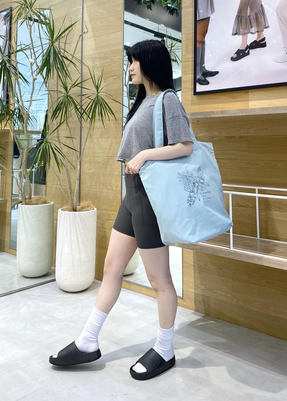 ブラック系のサンダル、グレー系のTシャツ/カットソー、グリーン系のトートバッグを着用したレディースの夏コーディネートの2枚目の写真