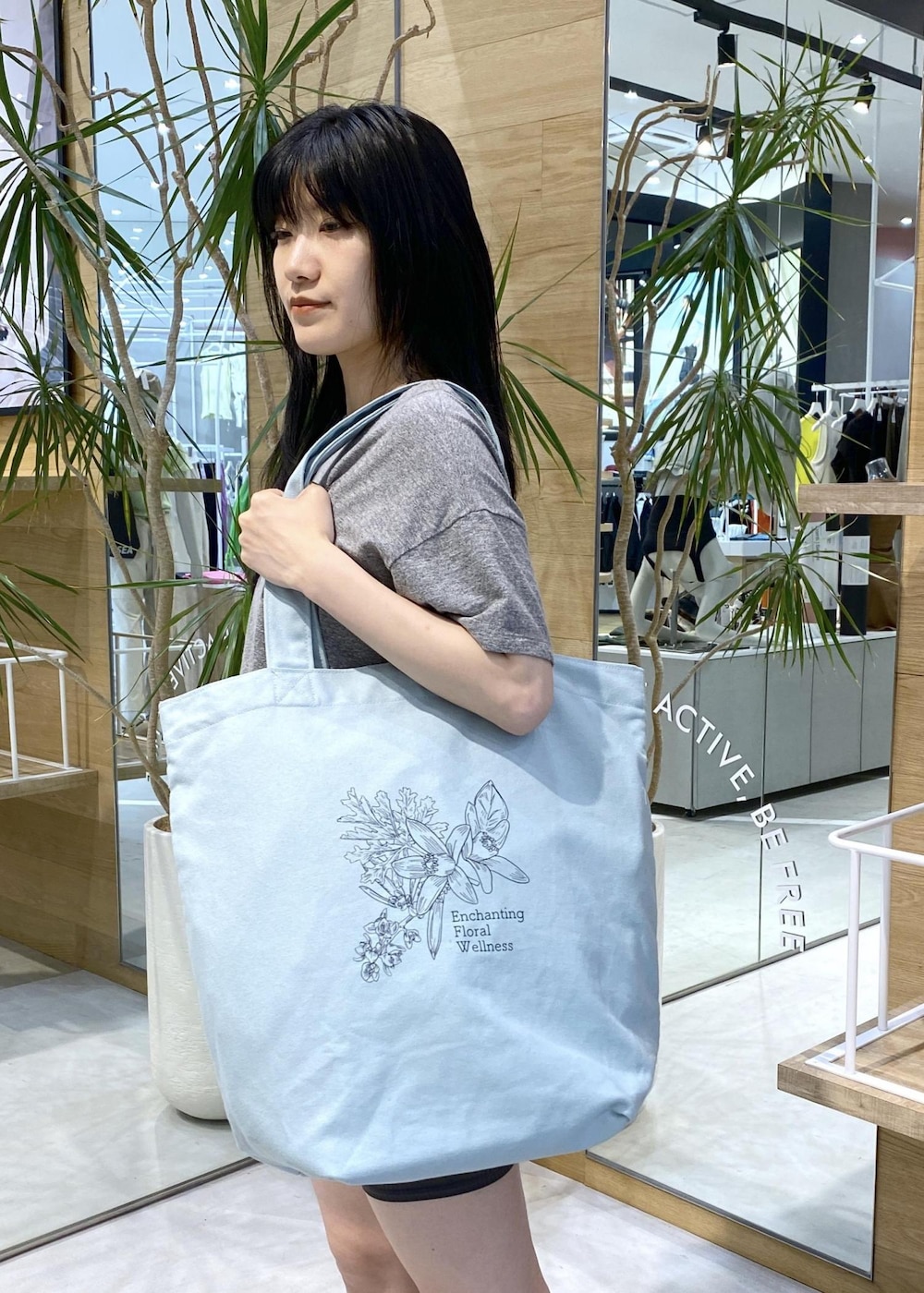 ブラック系のサンダル、グレー系のTシャツ/カットソー、グリーン系のトートバッグを着用したレディースの夏コーディネートの6枚目の写真