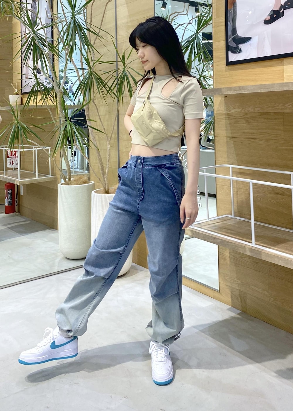 イエロー系のTシャツ/カットソー、イエロー系のボディバッグ/ウエストポーチ、ブルー系のデニムパンツを着用したレディースの夏コーディネートの4枚目の写真