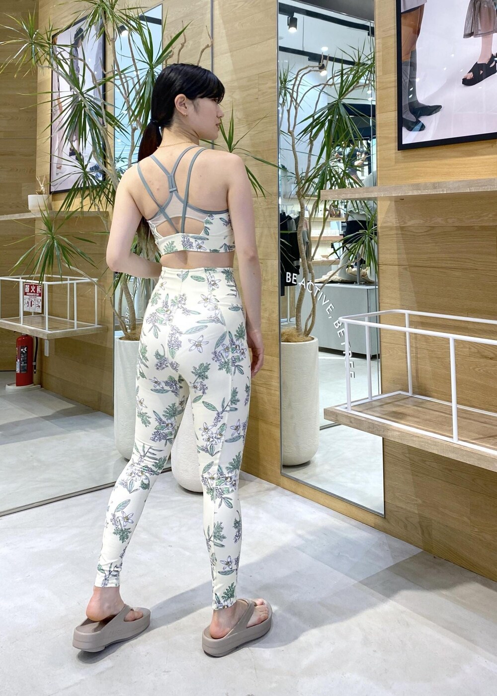 ベージュ系のサンダル、ホワイト系のラッシュガード、グリーン系のスポーツグッズを着用したレディースの夏コーディネートの6枚目の写真