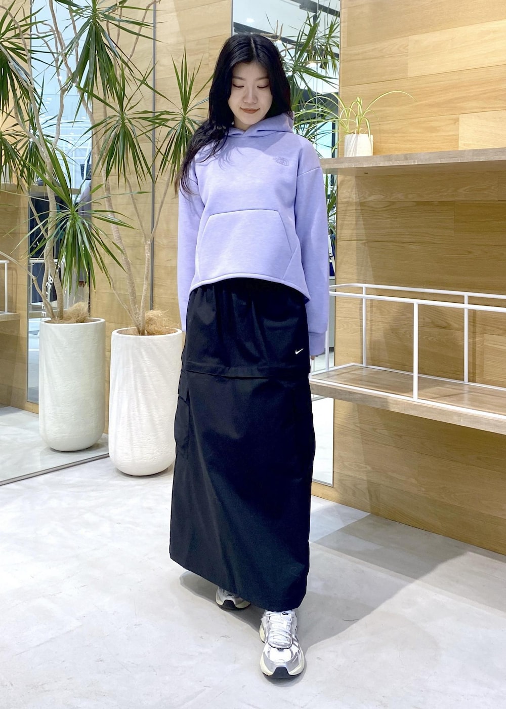 ホワイト系のスニーカー、パープル系のパーカー、ブラック系のスカートを着用したレディースの秋コーディネートの7枚目の写真