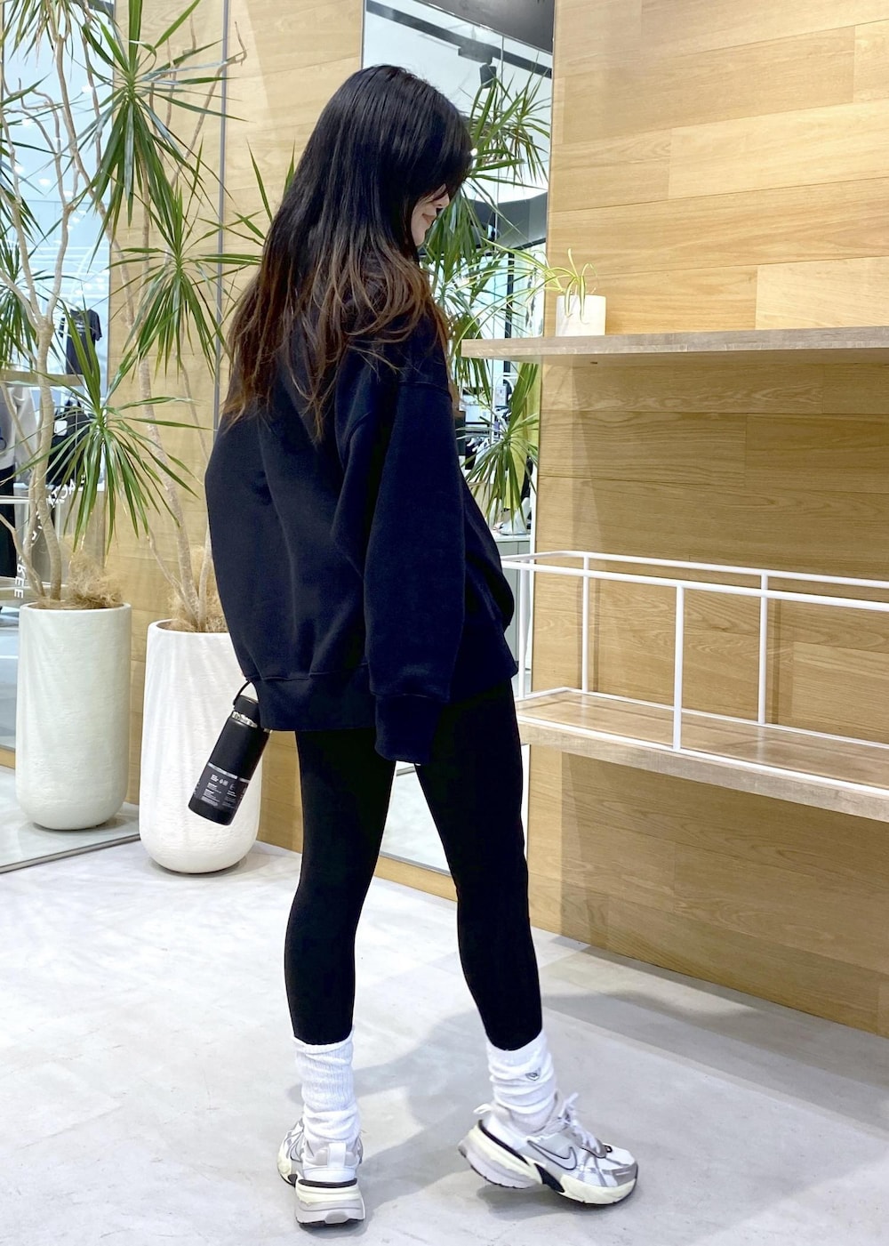 ホワイト系のスニーカー、ブラック系のスウェット、ブラック系のレギンス/スパッツを着用したレディースの秋コーディネートの4枚目の写真