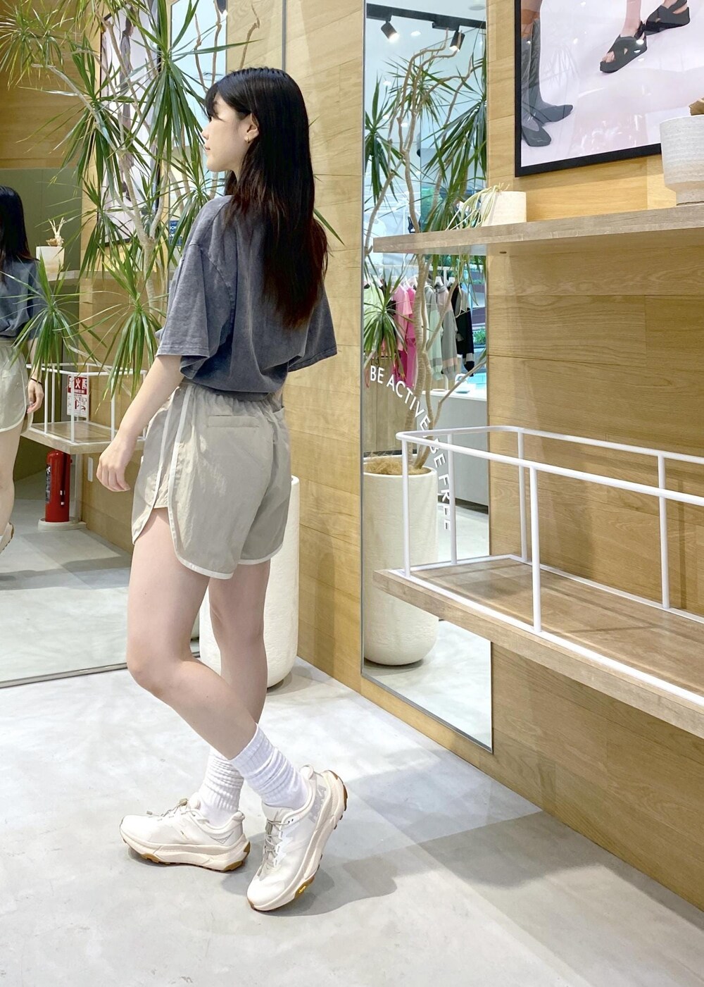 ブラック系のTシャツ/カットソー、ベージュ系のその他パンツ、ホワイト系のスニーカーを着用したレディースの夏コーディネートの2枚目の写真