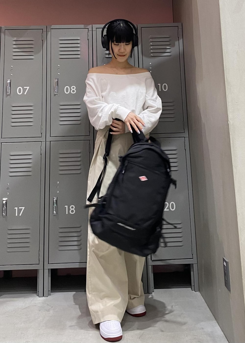 ホワイト系のTシャツ/カットソー、ホワイト系のスニーカー、ブラック系のバックパック/リュックを着用したレディースの冬コーディネートの4枚目の写真