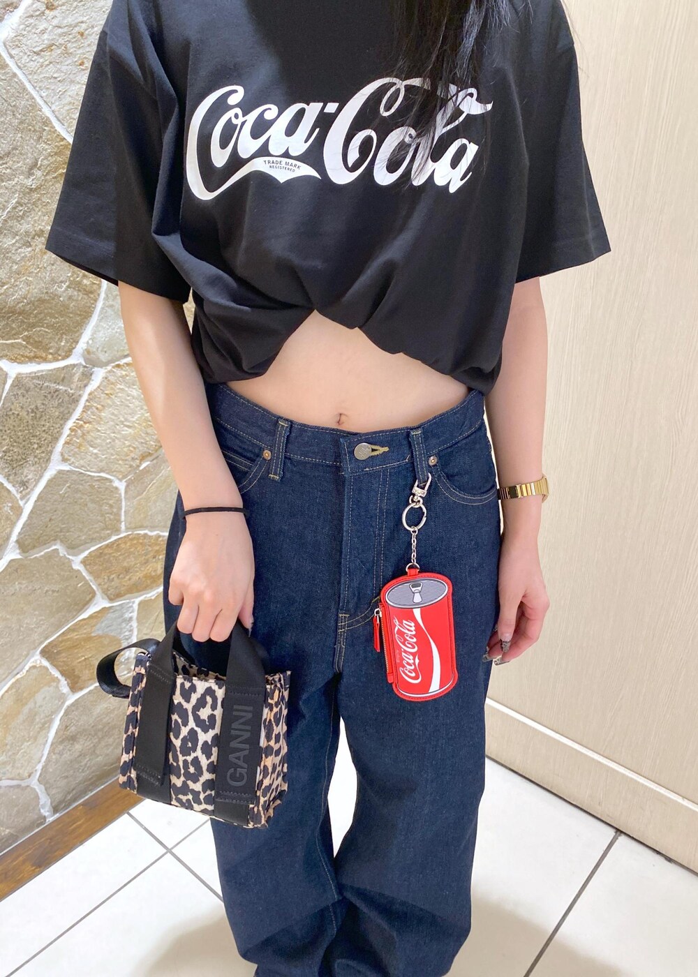 ベージュ系のスニーカー、ブルー系のデニムパンツ、ベージュ系のショルダーバッグを着用したレディースの夏コーディネートの5枚目の写真