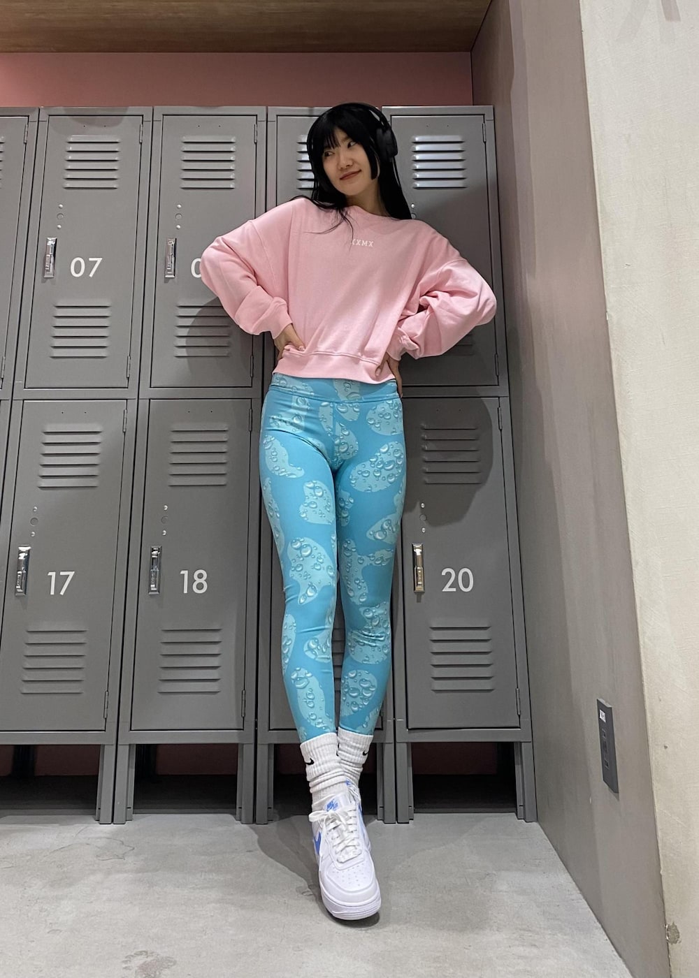 ピンク系のスウェット、ホワイト系のスニーカー、ブルー系のレギンス/スパッツを着用したレディースの冬コーディネートの3枚目の写真