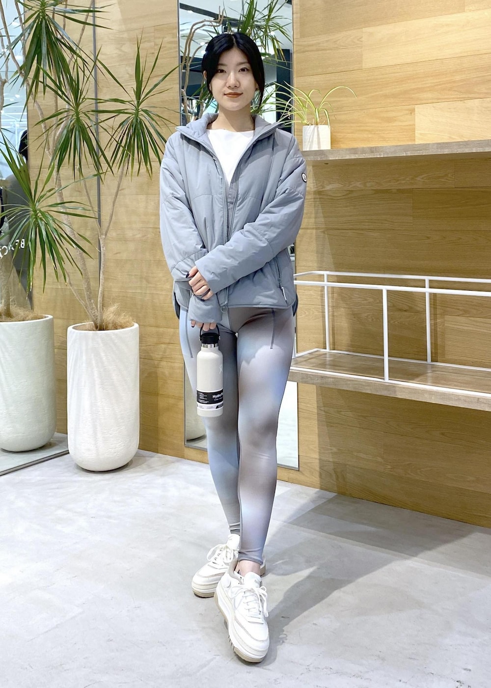 グリーン系のダウンジャケット/コート、ブルー系のレギンス/スパッツを着用したレディースの秋コーディネートの2枚目の写真