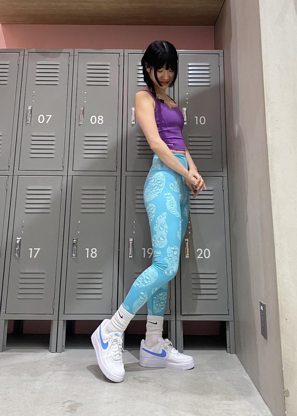 ホワイト系のスニーカー、パープル系のスポーツブラ、ブルー系のレギンス/スパッツを着用したレディースの冬コーディネートの2枚目の写真