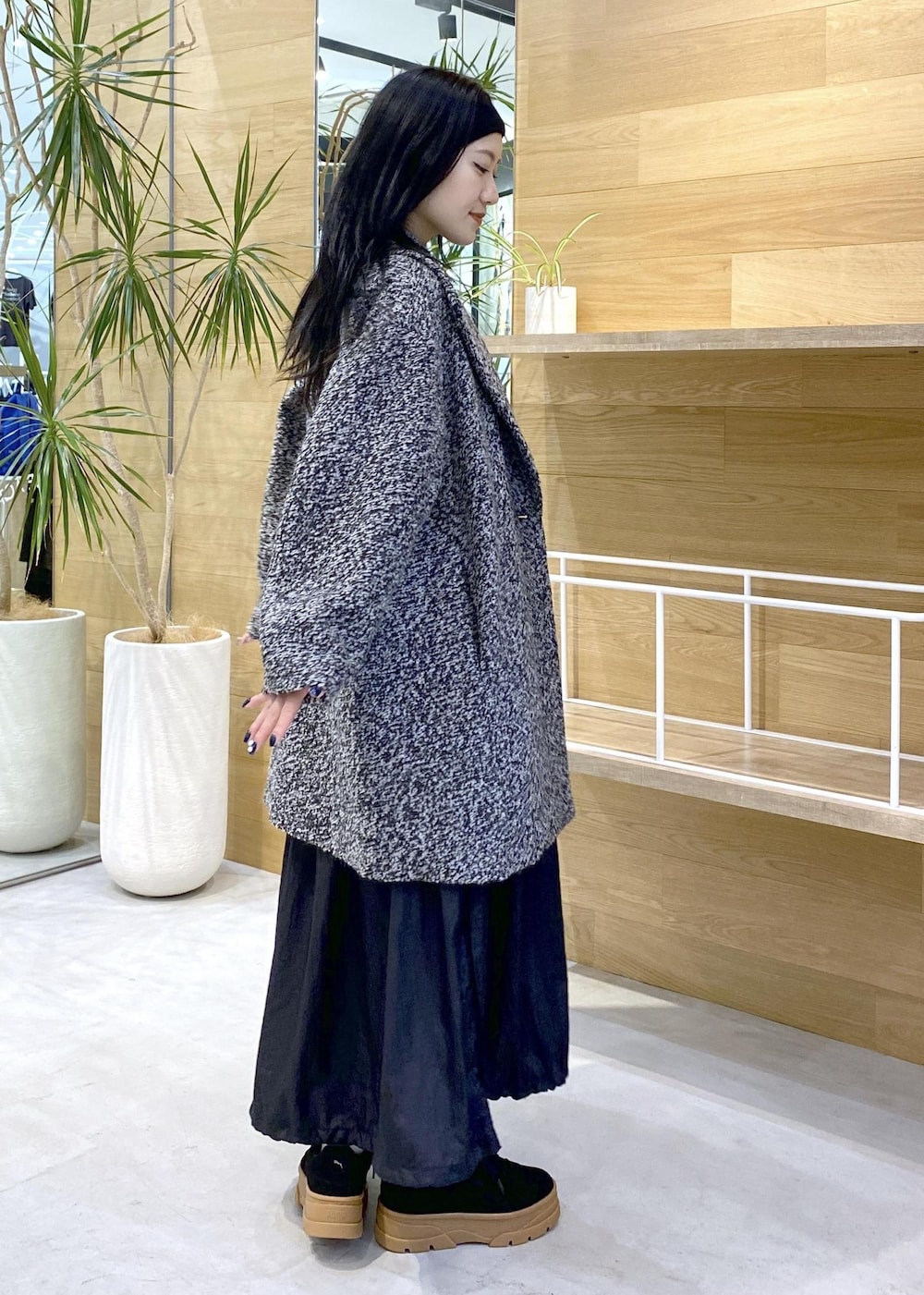 ブラック系のショルダーバッグ、ブラック系のワンピース、ブラック系のチェスターコートを着用したレディースの秋コーディネートの7枚目の写真