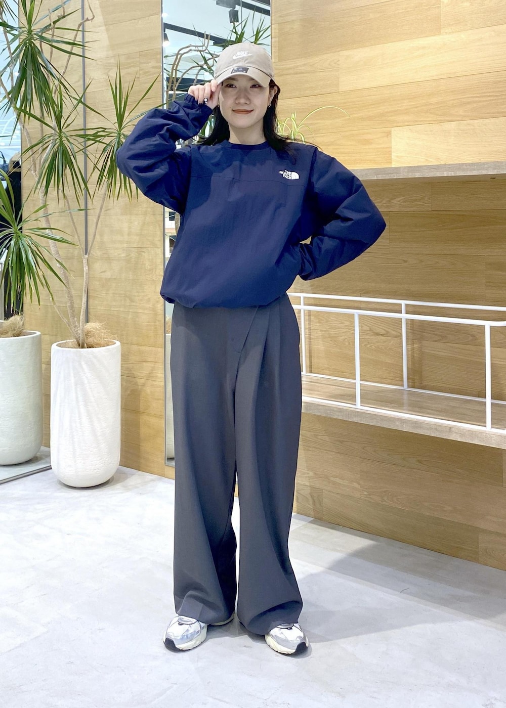 グレー系のスラックス、ホワイト系のスニーカー、ブルー系のその他トップスを着用したレディースの秋コーディネートの2枚目の写真