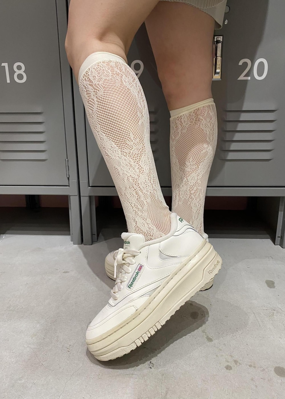 ホワイト系のスニーカー、グレー系のハンドバッグ、ブラック系のパーカーを着用したレディースの春コーディネートの5枚目の写真