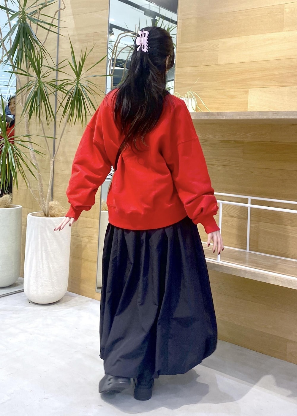 ブラック系のカーディガン/ボレロ、ブラック系のスニーカー、レッド系のスウェットを着用したレディースの冬コーディネートの5枚目の写真