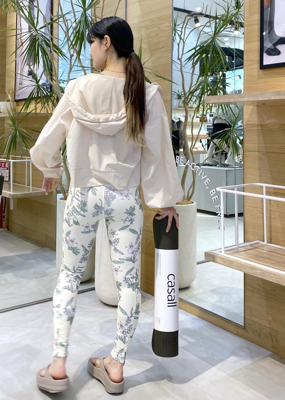 ベージュ系のサンダル、ホワイト系のラッシュガード、グリーン系のスポーツグッズを着用したレディースの夏コーディネートの4枚目の写真