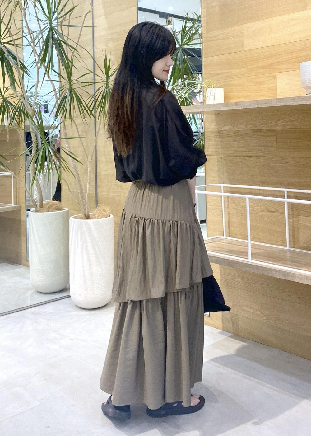 グリーン系のスカート、ブラック系のキャミソール、ブラック系のサンダルを着用したレディースの夏コーディネートの5枚目の写真