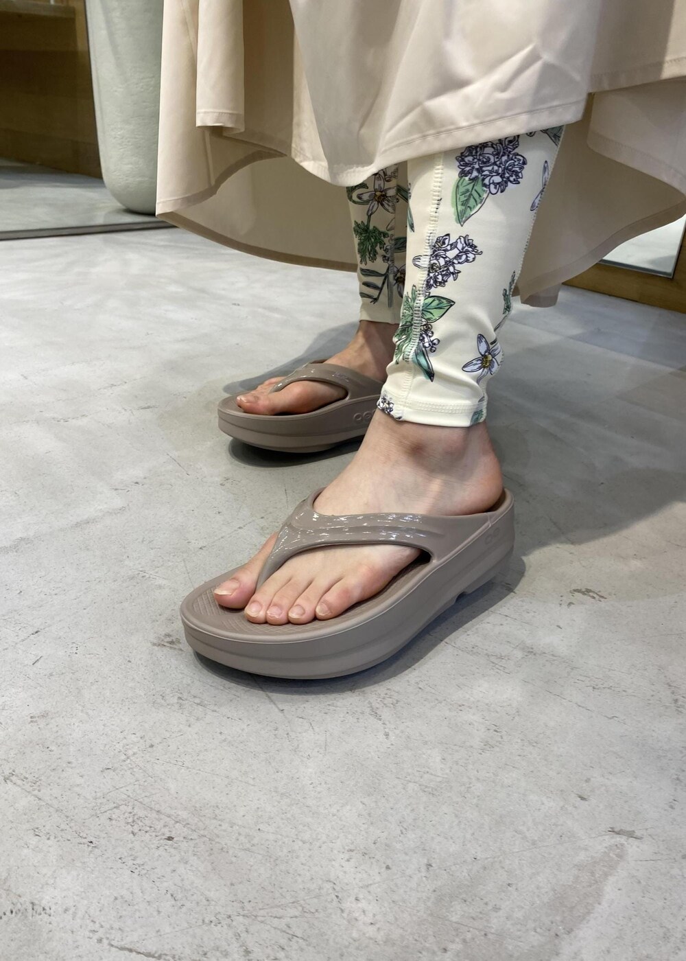 ベージュ系のサンダル、ホワイト系のラッシュガード、グリーン系のスポーツグッズを着用したレディースの夏コーディネートの7枚目の写真