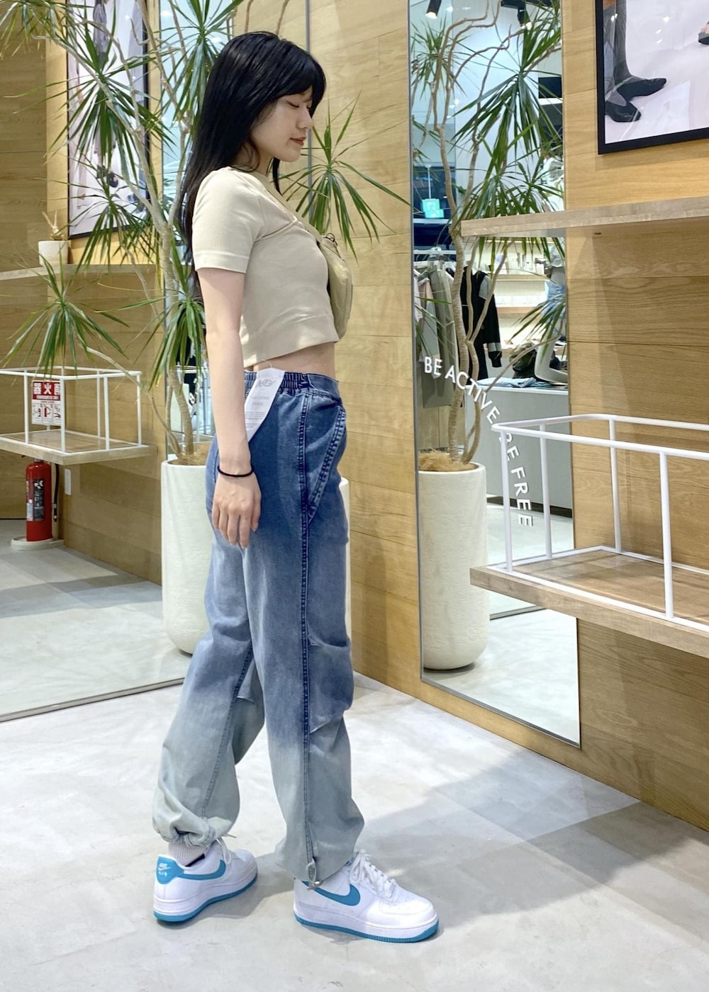 イエロー系のTシャツ/カットソー、イエロー系のボディバッグ/ウエストポーチ、ブルー系のデニムパンツを着用したレディースの夏コーディネートの2枚目の写真