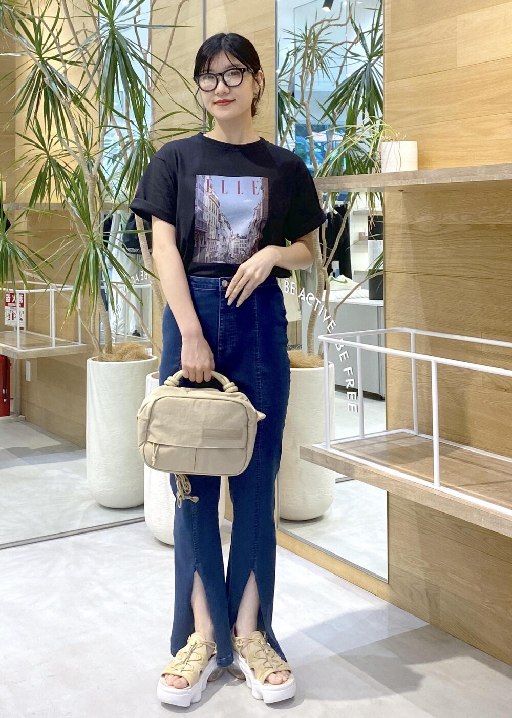 ブルー系のデニムパンツ、ベージュ系のサンダル、ブラック系のTシャツ/カットソーを着用したレディースの夏コーディネートの7枚目の写真