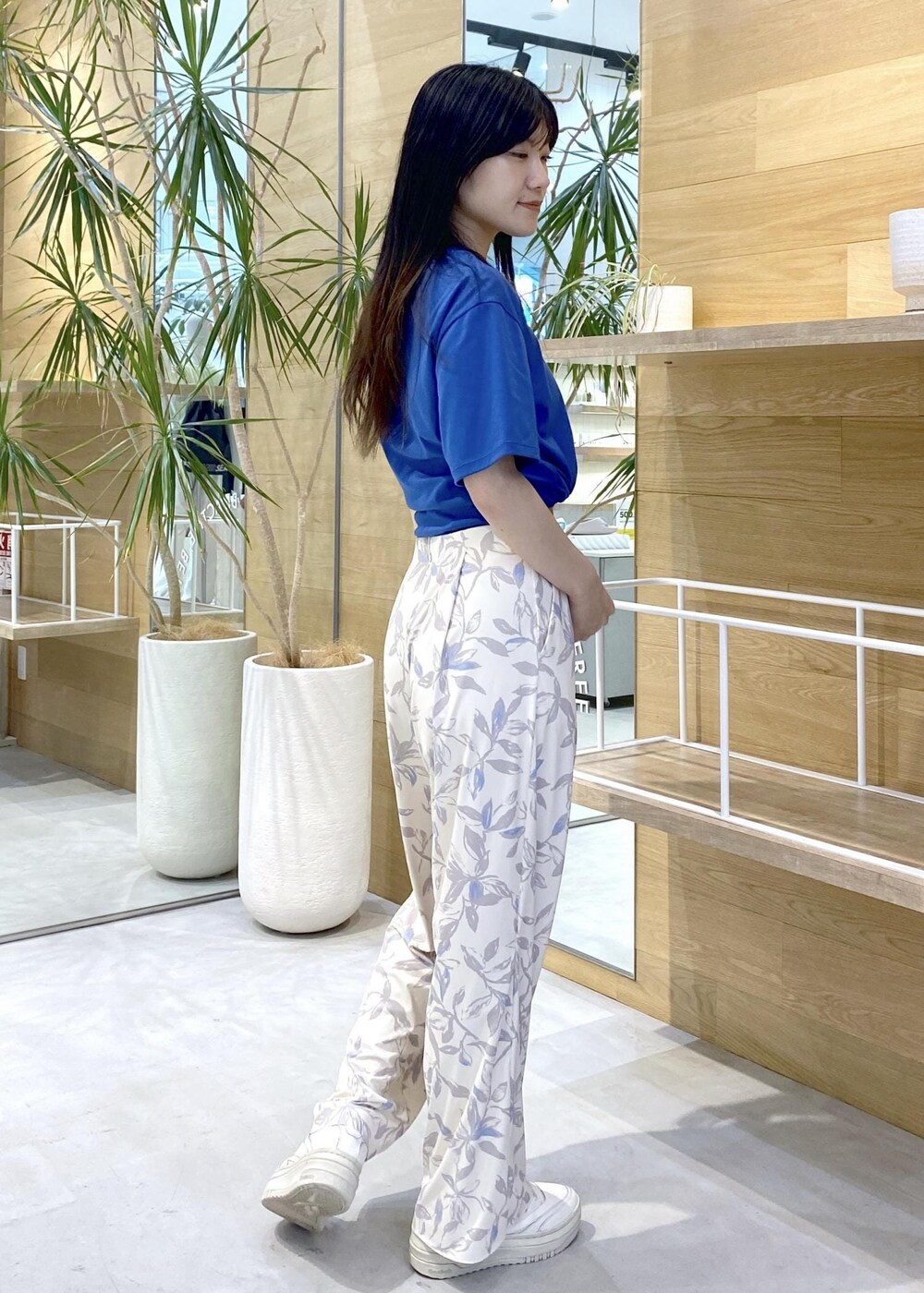 ベージュ系のその他パンツ、ホワイト系のスニーカー、ブルー系のTシャツ/カットソーを着用したレディースの夏コーディネートの5枚目の写真