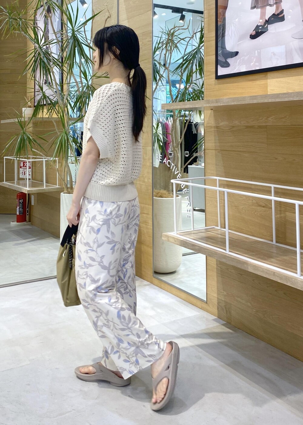 ベージュ系のその他パンツ、ベージュ系のサンダル、ホワイト系のニット/セーターを着用したレディースの夏コーディネートの3枚目の写真